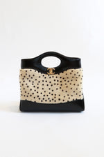 Chanel mini shopping tote with ivory calf hair hand-painted cheetah dot print, black leather trim, structured top handle, and gold CC turnlock from Métiers d'Art 2026 collection by Matthieu Blazy 