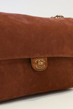 Chanel camel/cognac suede Souplissimo Maxi Flap bag with quilted body, gold CC turnlock closure, and woven chain strap