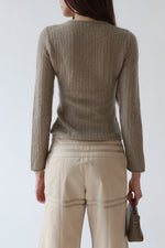 Back close-up view of a vintage Giorgio Armani taupe mohair crew neck sweater with long slim sleeves and rolled cuffs, styled with vintage Giorgio Armani sand flare trousers, the Row sandals, Loro Piana mini L19.