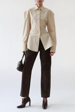 Front view of vintage Gucci dark brown leather V-cut booties with a square toe and angular heel, styled with The Frankie Shop beige structured shirt, vintage Gucci brown suede trousers, and Miu Miu brown nappa leather shoulder bag.